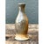 This vintage stoneware vase presents a slender, elegant silhouette, its form swelling gently at the shoulder before...