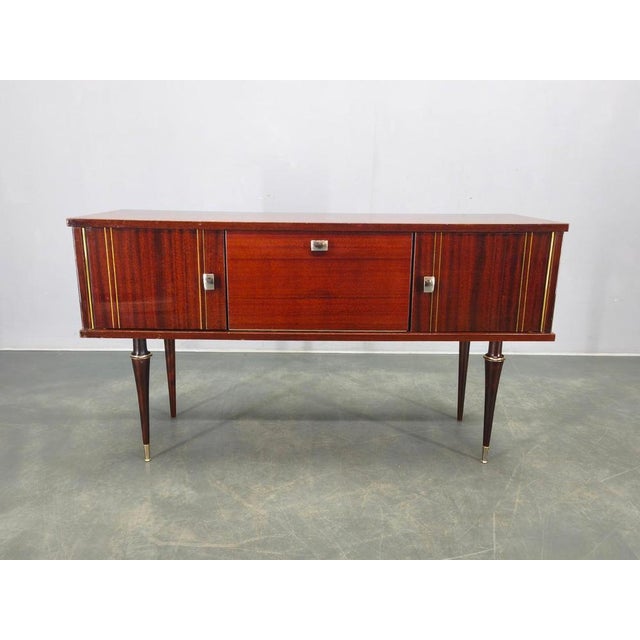 Refined italian mid century sideboard from the 1950s, executed in richly figured wood veneer with an elegant high gloss...