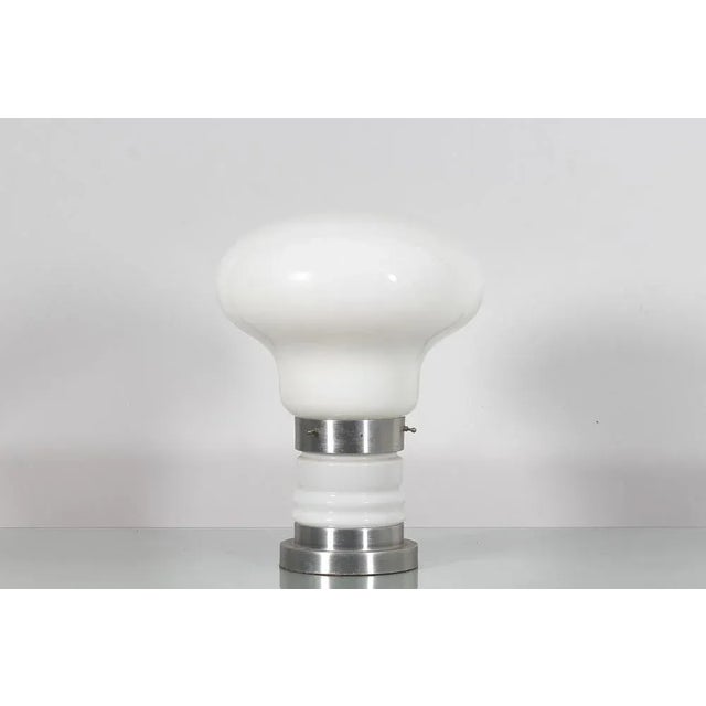 Beautiful example of a table lamp with a 70s design, in white Murano glass, with a base and globe that give the lamp the...
