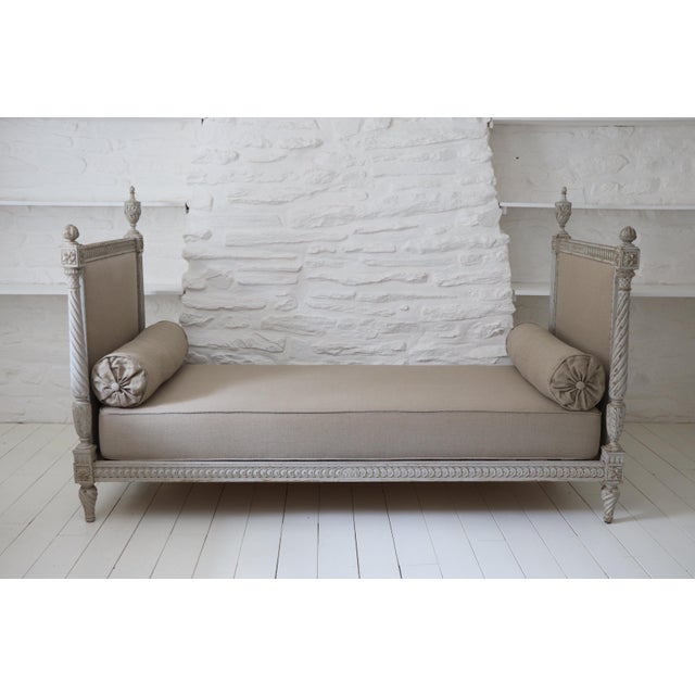 An elegant Louis XVI style daybed, dating from the early 19th century. Made of molded wood and richly carved with acanthus...