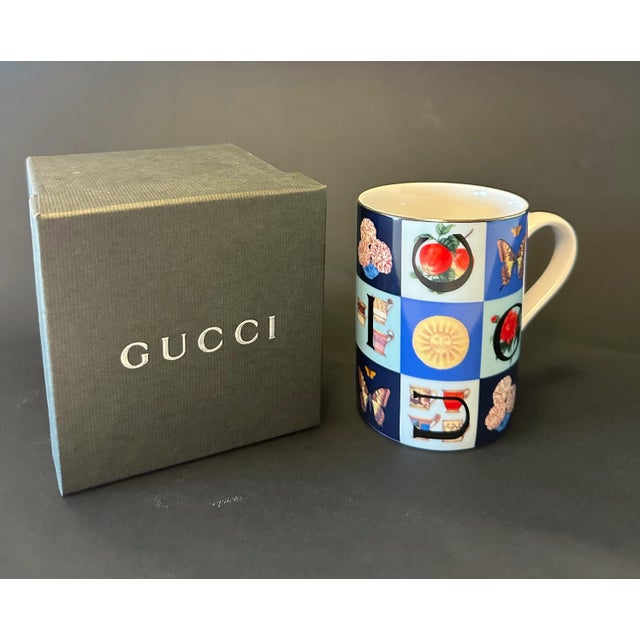 "Guccissimo" porcelain mug featuring bright polychrome design with a predominance of blue and large letters forming the...