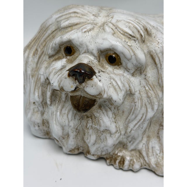 This is a charming vintage glazed ceramic dog figurine, modeled as a long-haired companion dog, likely inspired by a...