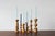 A decorative set of seven wooden candleholders of varying heights and individually designed, turned shapes. Each has its...