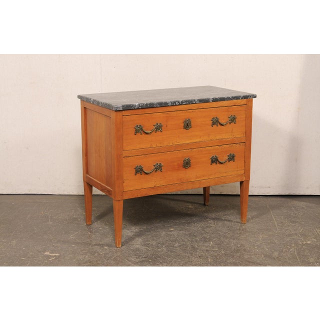 A French wooden two-drawer chest with marble top from the 19th century. This antique chest from France has a rectangular...
