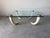 Striking vintage coffee table featuring four sculptural faux elephant tusk legs supporting a thick glass top with solid...