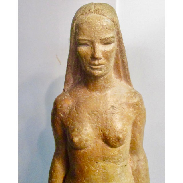 Terra-cotta sculpture of the Earth Mother circa 1950s. Standing full frontal with small drapery at knees, small globe,...