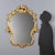 Barocchetto style mirror crafted in carved and gilded wood, featuring a molded frame with refined floral carvings and...