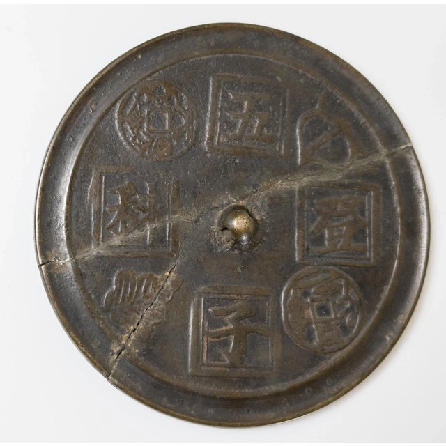 We are selling this Chinese early style bronze mirror. The bronze mirror has four character decoration and two coin...
