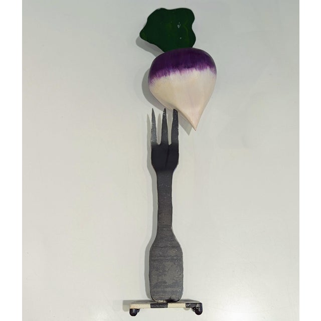 Late 20th-century sculpture in forged iron, skewering a painted turnip atop checkerboard base. Graphic and playful,