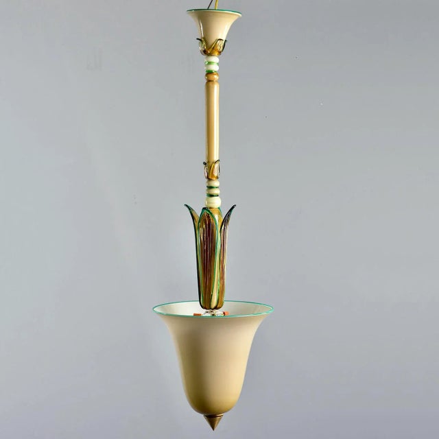 Circa 1930s Venini of Italy Murano glass pendant features a bell-shaped ecru colored globe with brass hardware, amber...