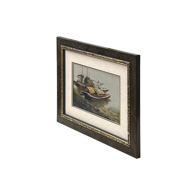 This framed piece is a striking example of East Asian silk embroidery, specifically capturing a serene river scene with...