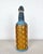 Vintage European wire wrapped bottle. Glass bottle wrapped on plastic wire. Attractive blue, black, and brown design.