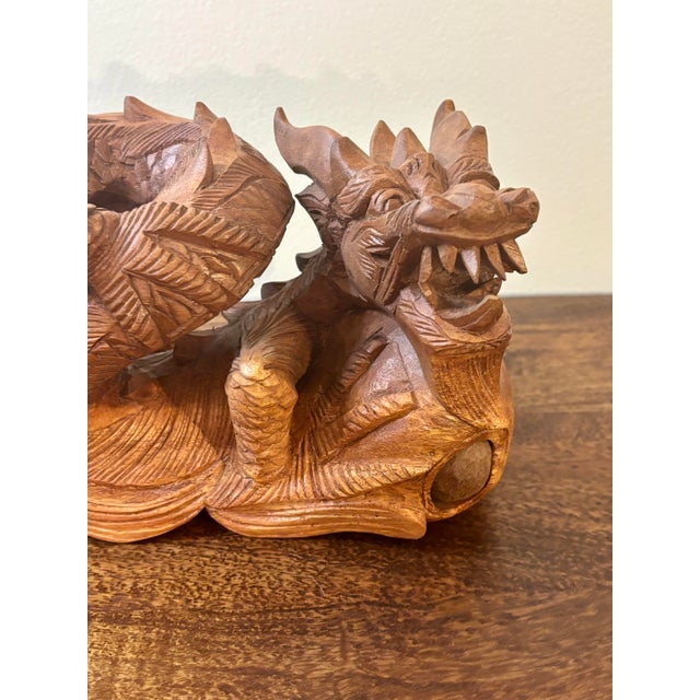 A vintage Chinese hand-carved dragon sculpture, carved from two-toned wood with strong detailing and expressive form. The...