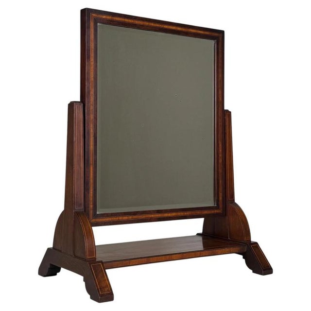 A charming and finely crafted early 20th-century English dressing mirror, beautifully constructed from mahogany and...