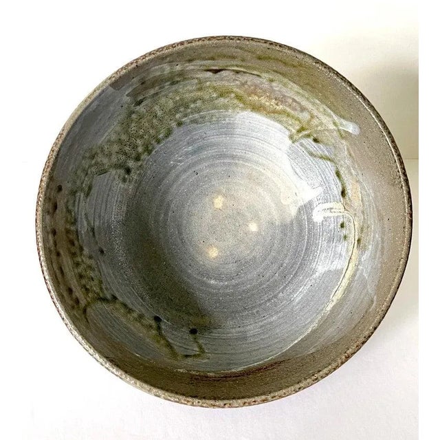 A large ceramic bowl by Japanese American artist Toshiko Takaezu (American, 1922 - 2011). The deep form bowl features a...
