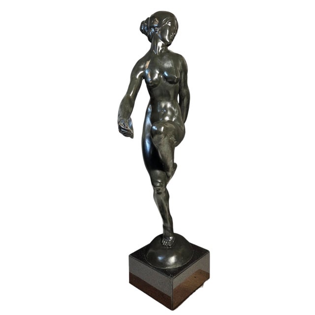 A large and elegant original French Art Deco bronze sculpture of a nude female figure poised in a graceful, balletic step....