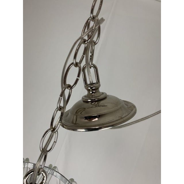 Dramatic and luminous, this sculptural chandelier features cascading tiers of hand-formed clear glass loops, meticulously...