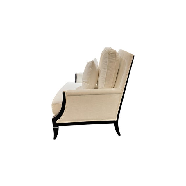 A sophisticated Ethan Allen accent chair featuring a striking black wood frame paired with soft ivory upholstery. The...