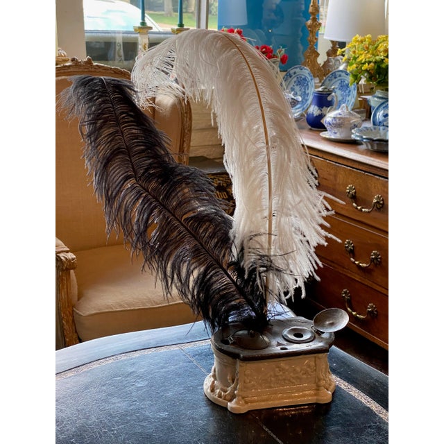 The heavy iron top has two inkwells which sit above the wonderfully shaped ceramic base with cherubs.