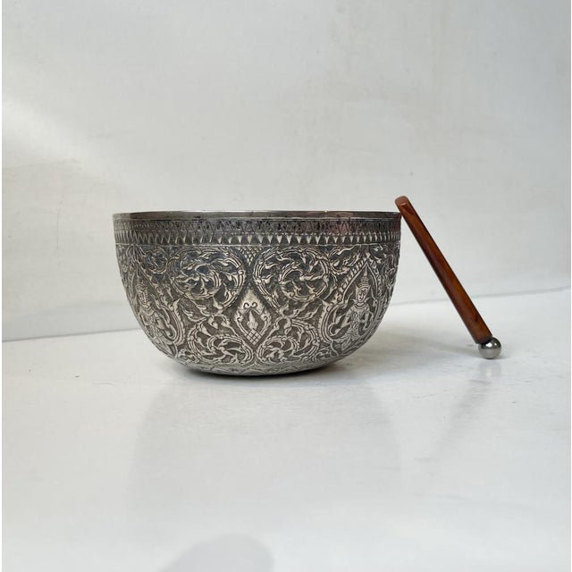 East Asian singing bowl carved and decorated excessively in repousse silver (850/1000). Buddhist theme high-lighted with...