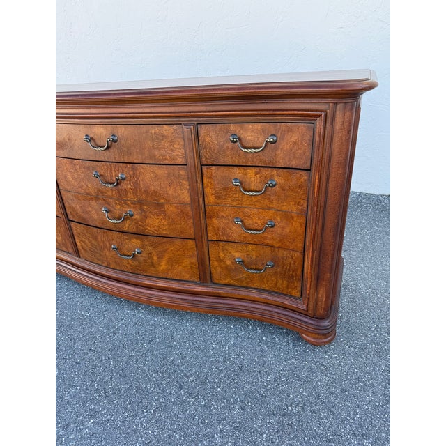 Thomasville British Gentry burled wood nine drawer dresser. It features burl oak panels and antiqued brass hardware .The...