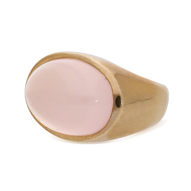 Soft blush oval pink quartz cabochon bezel-set in a smooth, high-polish domed 14K yellow gold signet mounting, weighing...