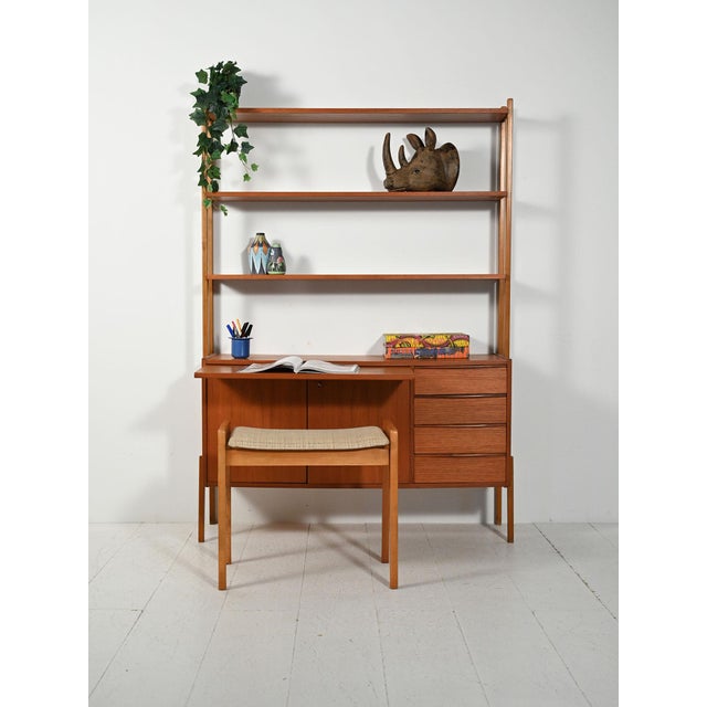 Scandinavian teak bookcase from the 1950s and 1960s with storage cabinet, drawers, and a built-in pull-out desk. An...