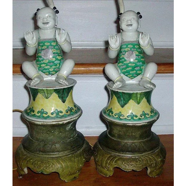 An exceptional pair of early Chinese porcelain figures of Ho Ho Boys in the Kangxi taste mounted as lamps. Wonderful...
