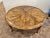 Guy Chaddock round carved wood French style coffee table with a geometric planked top, scalloped apron, four thick, short...