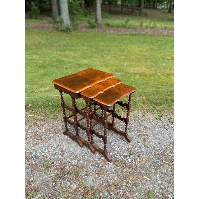 Attractive set of three 19th century nesting tables with burled walnut tops, scalloped and beveled edges, and trestle...