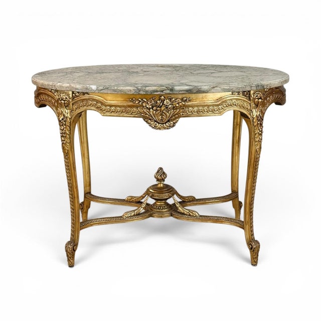 19th Century French Louis XVI Gilded Marble Top Oval Center Table features marble in a warm neutral beige, accented by...