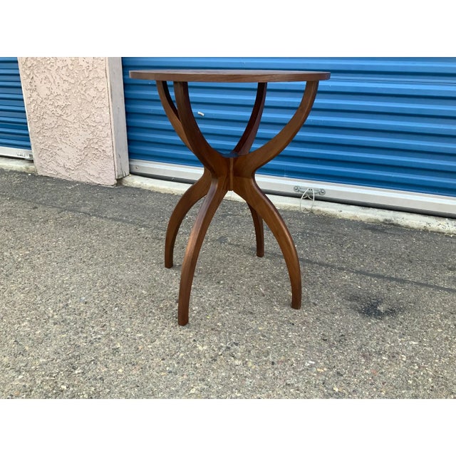 Modern walnut end table. Table is quite unique with extended tripod legs . Table is made of walnut. The modern table is...