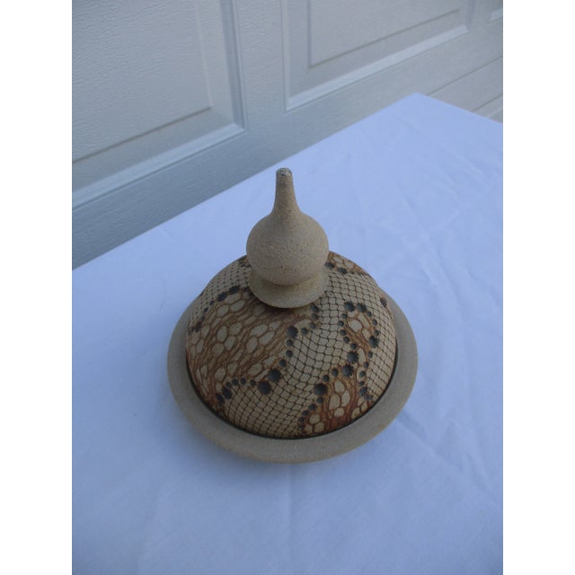 A signed domed cheese dish by Don McWhorter in a snakeskin pattern. This piece of studio pottery looks amazing from every...