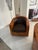 A pair of sculptural barrel-back lounge chairs featuring thick, curved wood frames with a striking, highly figured grain...