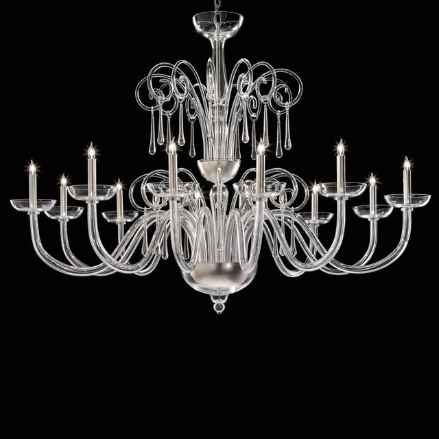Elegant and sinuous chandelier in trasparent blowing Murano glass and chromed metal frame. Shenographic italian chandelier...