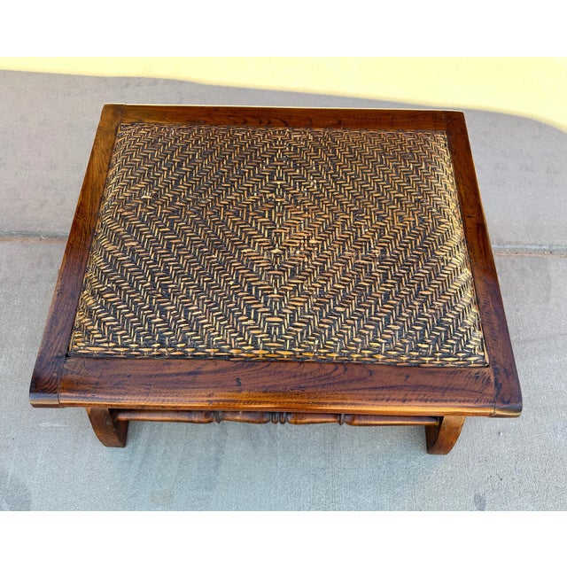 Indonesian Wood/Rattan Foot Stool. Solid wood with a woven rattan cushion top. 22in d x 24in w x 12.75in h (to top of...