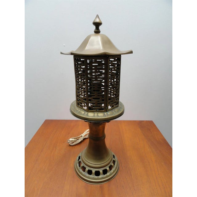 A beautifully crafted mid-century brass table lamp inspired by traditional Chinese pagoda lanterns, featuring intricate...