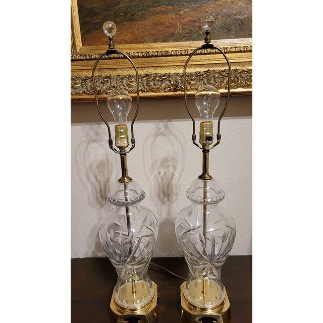 Beautiful pair of cut glass lamps with hexagonal cream color lamp shades. Brass base with Asian design and a cut crystal...