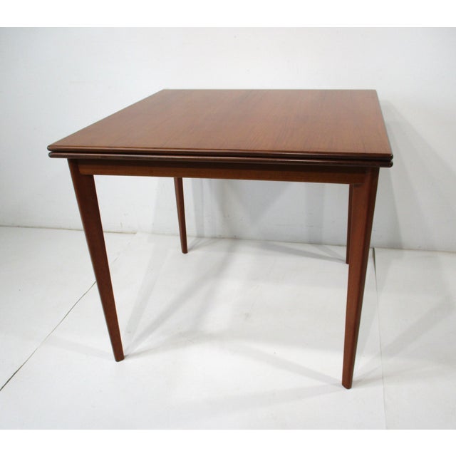 A very well crafted beautifully grained walnut folding dining or game table with brass hinges and darker bullnose edges ....