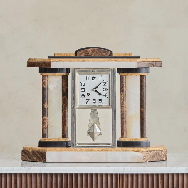 A French Art Deco mantel clock garniture set from the 1930s, composed of a central marble clock and a pair of coordinating...