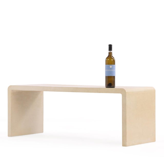 A sophisticated contemporary waterfall-form coffee or end table, clad entirely in parchment in the manner of Jean-Michel...
