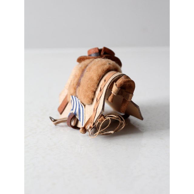 This vintage folk art piece from Uruguay showcases a meticulously crafted miniature pack, complete with hand-stitched...