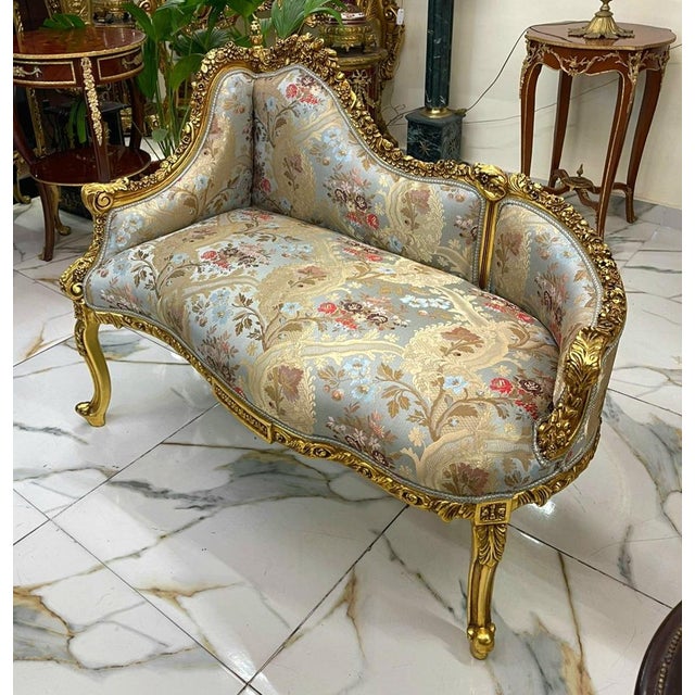 This elegant French Rococo-style settee features a beautiful sky blue and neutral floral-patterned upholstery complemented...