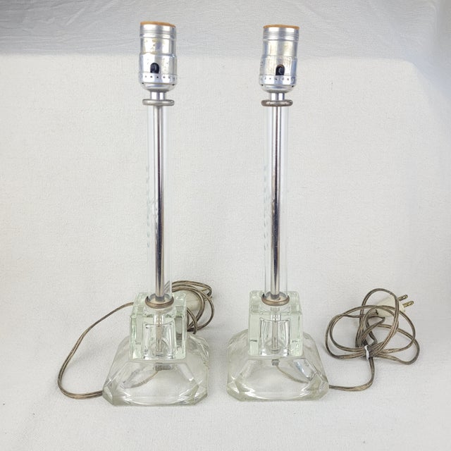 Pair of vintage glass candlestick lamps featuring a sleek, tall profile with elegant etched detailing on the central glass...