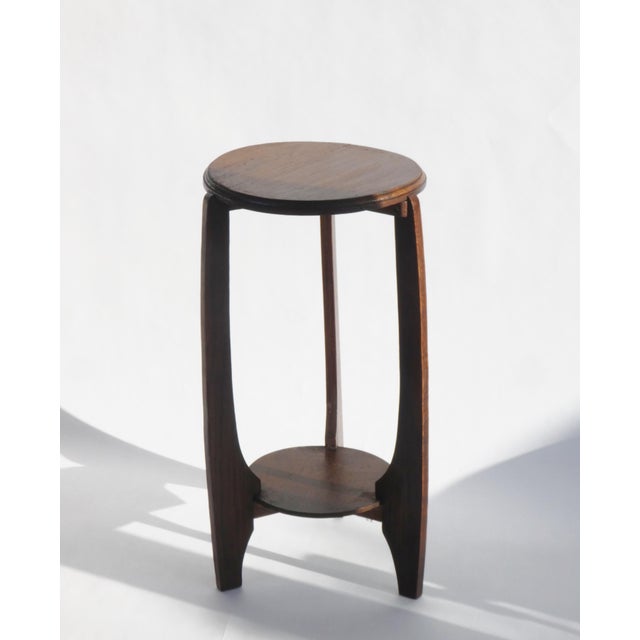 An antique Art Deco two tiered pedestal made out of oak wood. The table is made in the Netherlands in the 1920's in the...