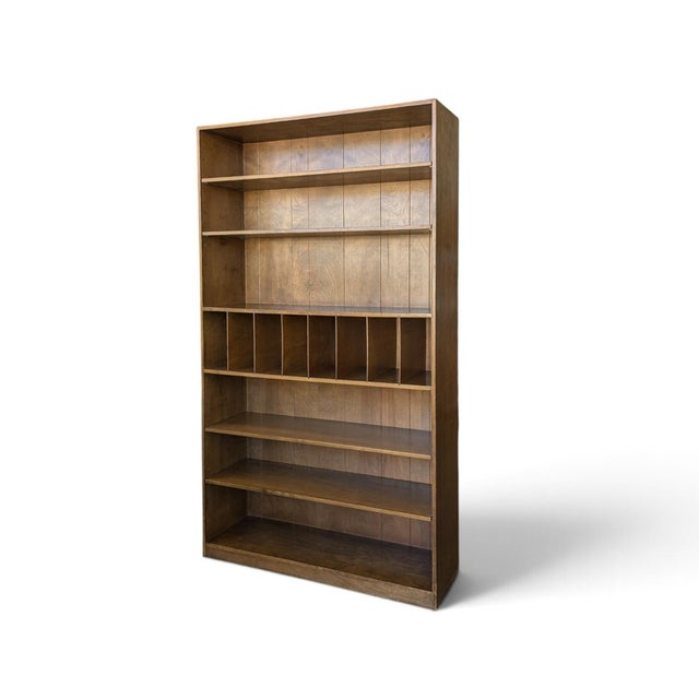 A tall Japanese bookcase with a clean architectural grid, adjustable shelves, and movable vertical dividers. The veneered-...
