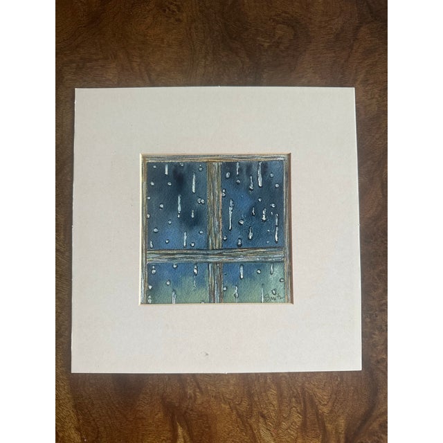 A contemplative watercolor capturing raindrops cascading down a weathered windowpane. Deep blue and gray tones evoke the...