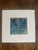 A contemplative watercolor capturing raindrops cascading down a weathered windowpane. Deep blue and gray tones evoke the...