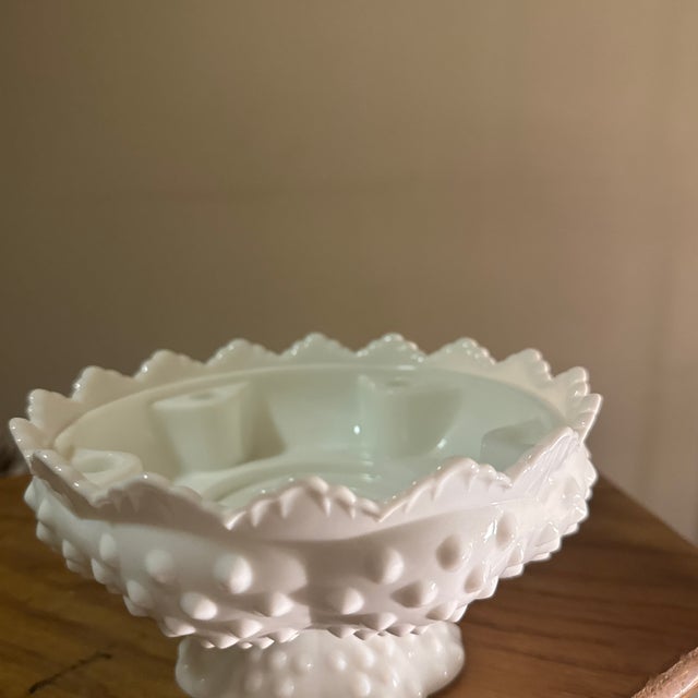 A timeless milk glass taper candle holder, showcasing the soft opaque glow and sculptural simplicity that make milk glass...