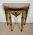 Elegant Italian demi-lune console table crafted in carved polychromed wood and topped with a shaped marble surface. Raised...
